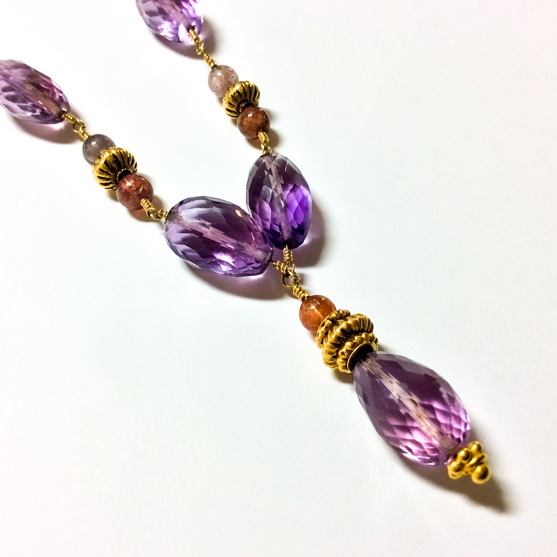Closeup view of amethyst necklace showing 22K gold wire wrapping and antiques India high karat gold beads