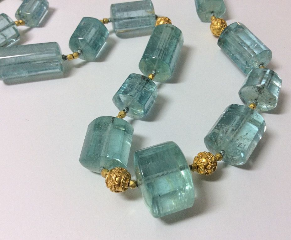 Closeup of aquamarine polished crystals with 20K Bali granulated beads