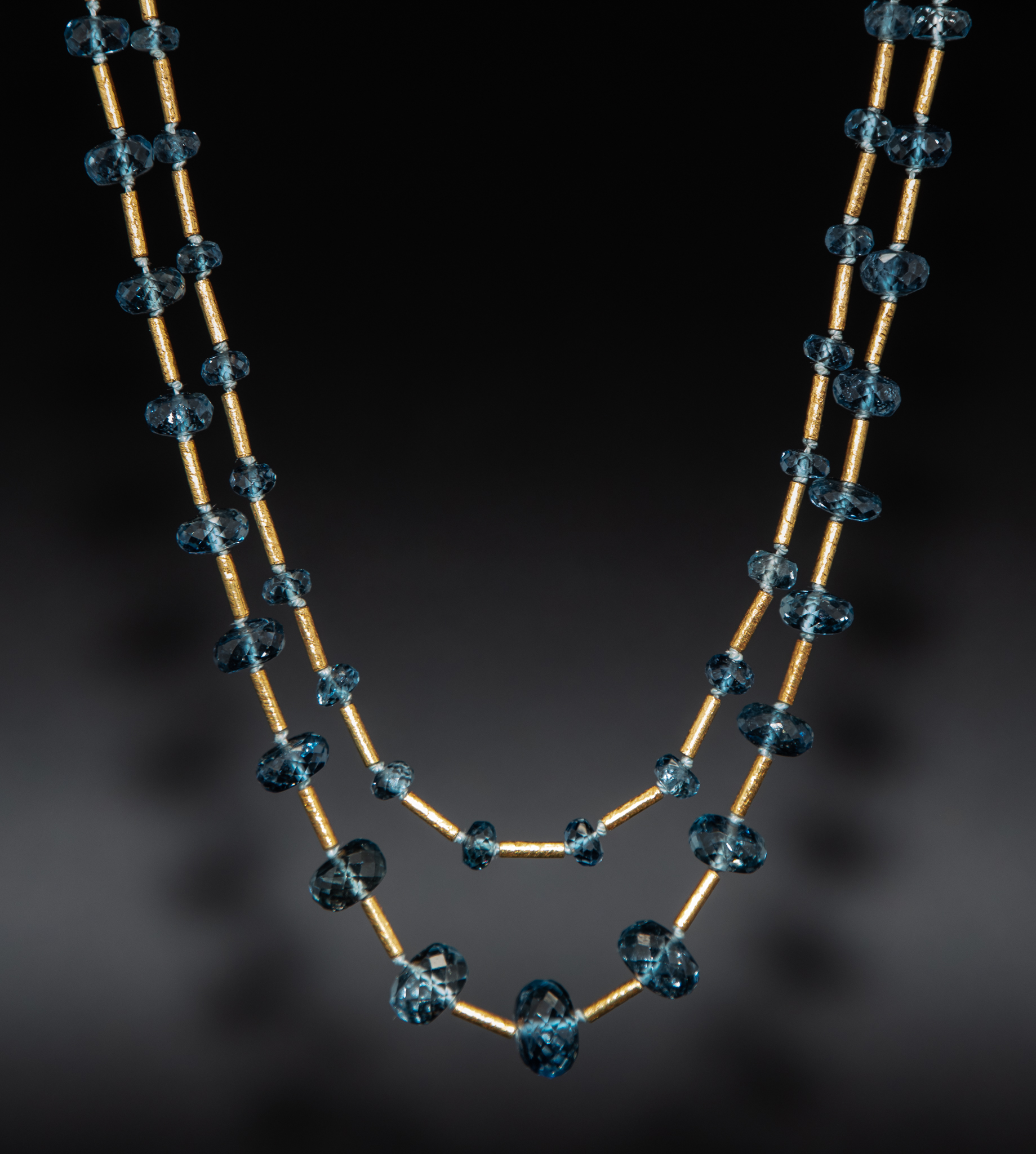 Delicate deep blue faceted aquamarines in double strand spaced with 18K Turkish gold textured tubes