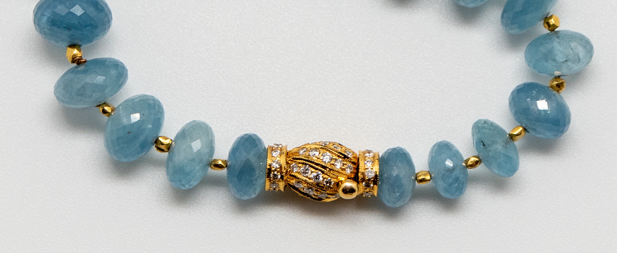detail of vintage 18K yellow gold barrel-shaped clasp with diamonds on opaque aquamarine beaded necklace