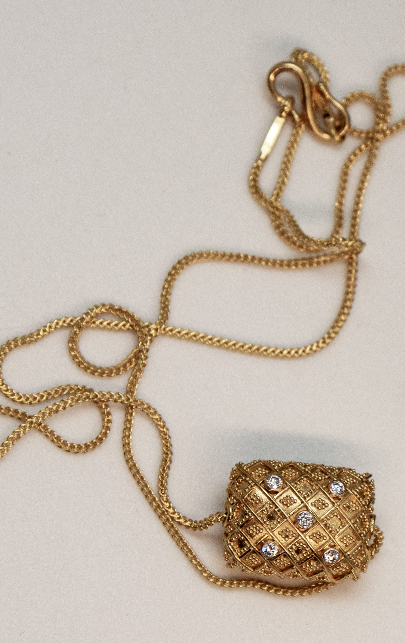 detail of Bali 22K gold bead pendant on matching chain with double S curve clasp
