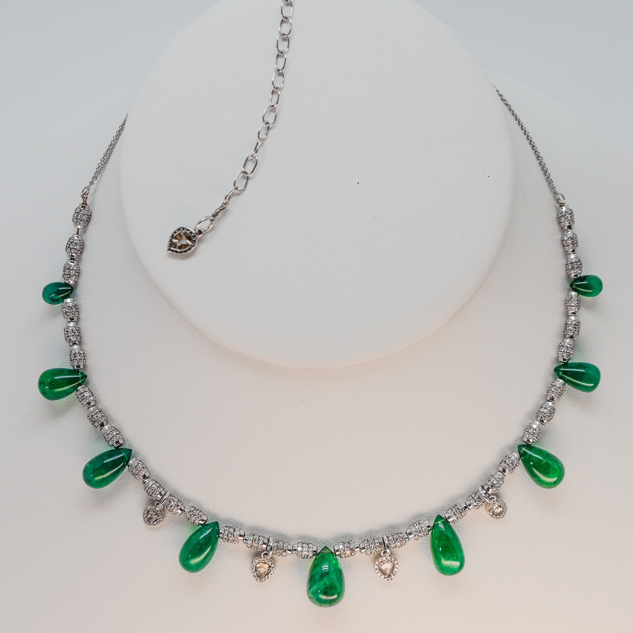 emerald and diamond bead necklace on display showing diamond charm at the end of the adjustment chain