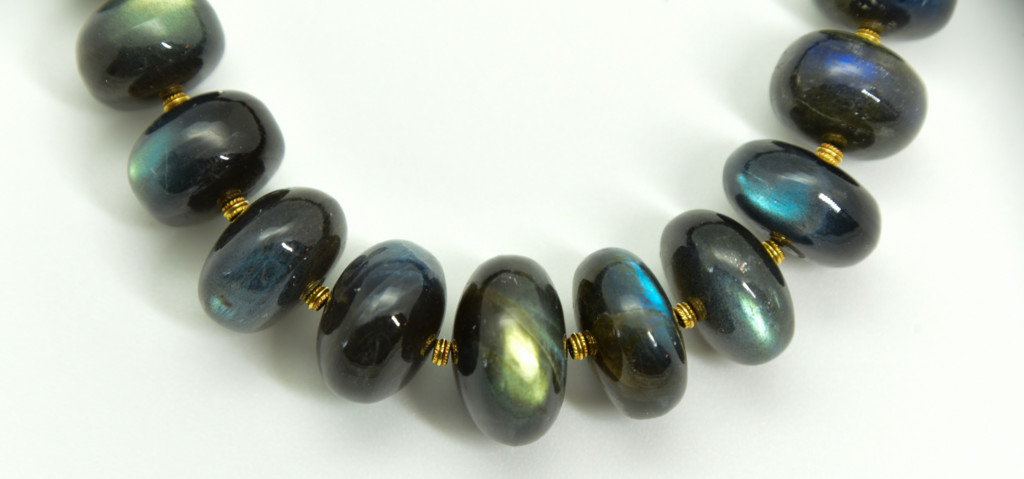 Close-up photo of labradorite beads separated by 18K gold rondelles