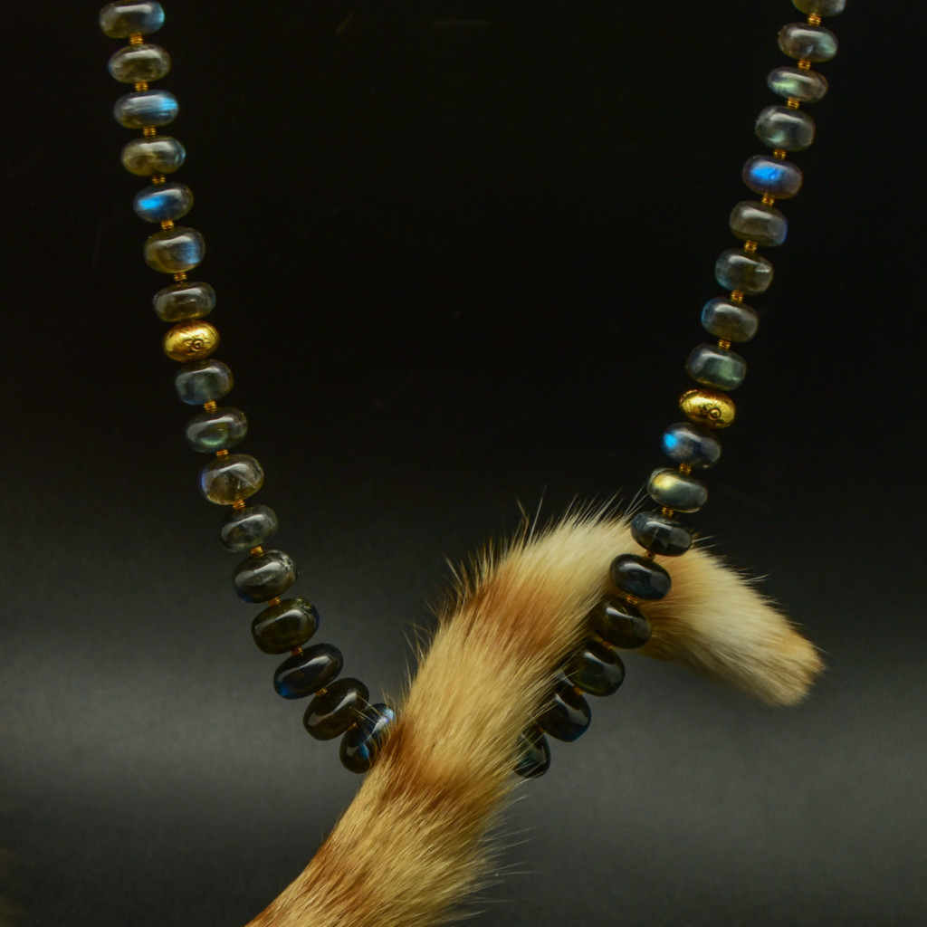 Bento kitty has his tail curved around a labradorite necklace- end of story