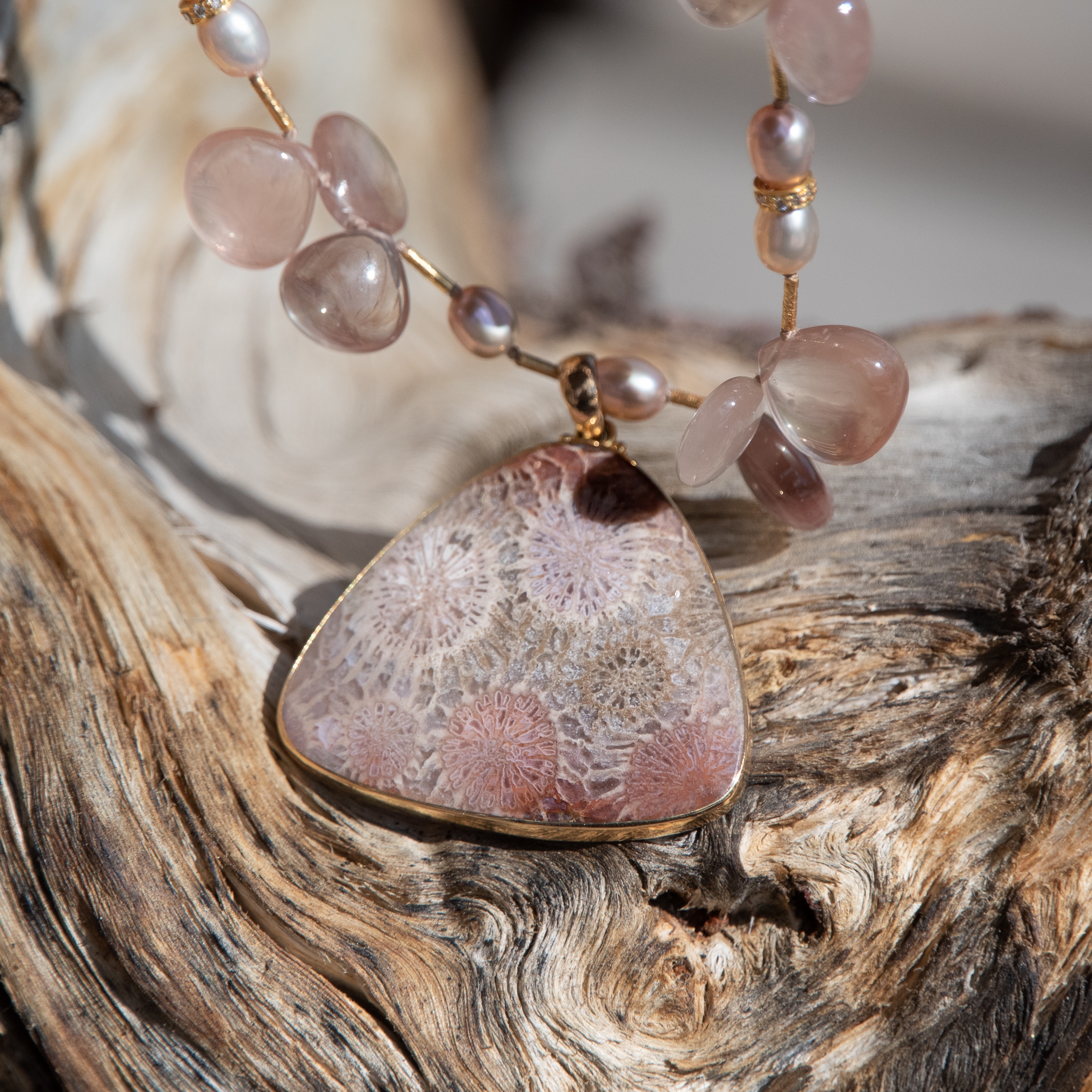 Detail of fossil coral pendant in mauves and grays
