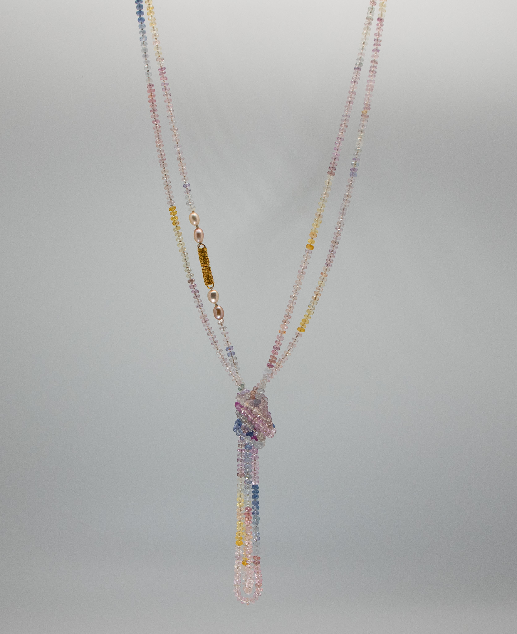 delicate multi-color sapphire necklace shown wrapped twice with pearl and 22K god clasp featured