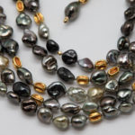 close-up of Tahitian Keshi pearls with 18K gold beads similarly shaped as the pearls. The rich gold color complements the gray and golden pearls.