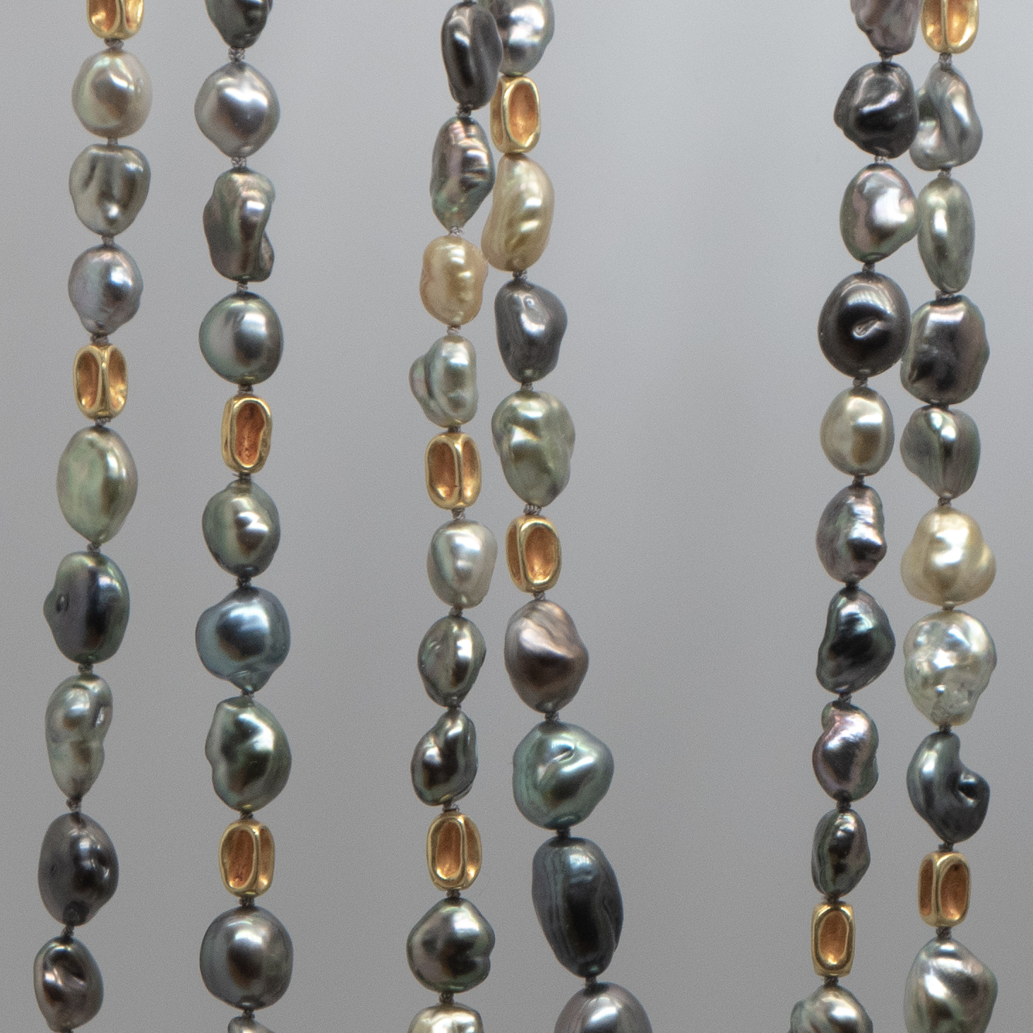 Close up photograph of Tahitian Keshi pearls with 18K gold beads
