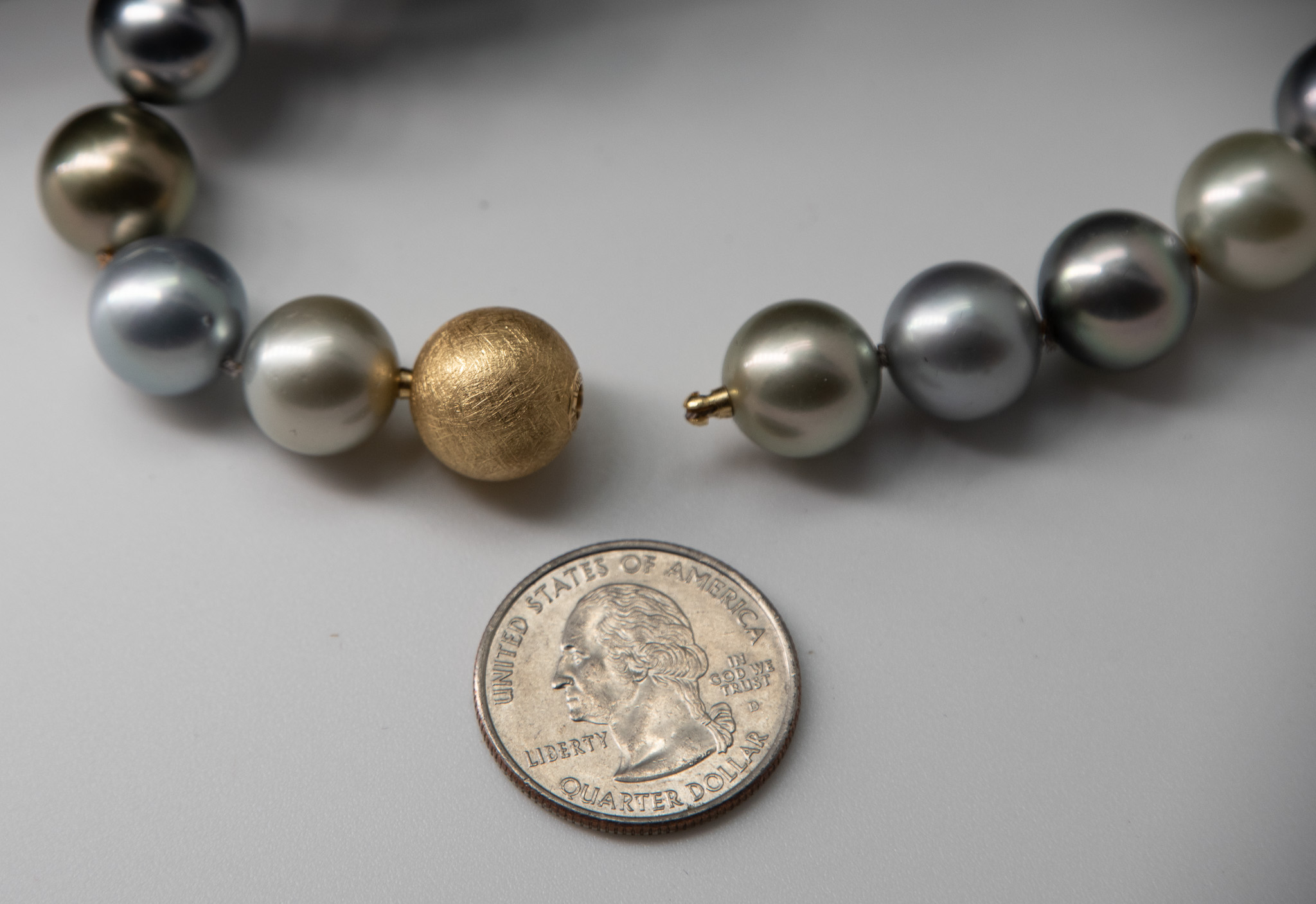 'Opera Night" Tahitian pearl opera-length necklace showing closeup of 18K gold Jorg Heinz tube and key clasp with US quarter coin for scale