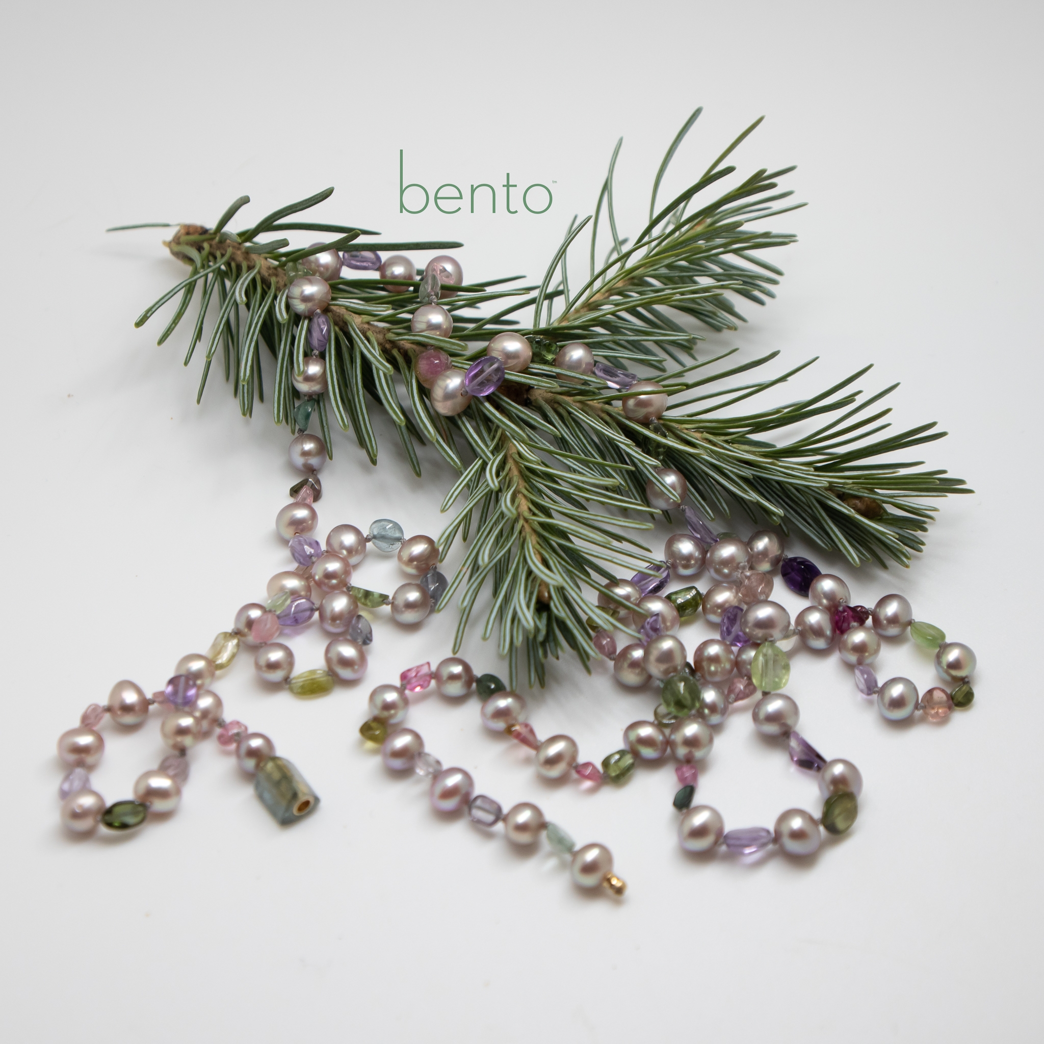Pretty freshwater pearl and tourmaline cabochon bead necklace photographed on a sprig of Spruce