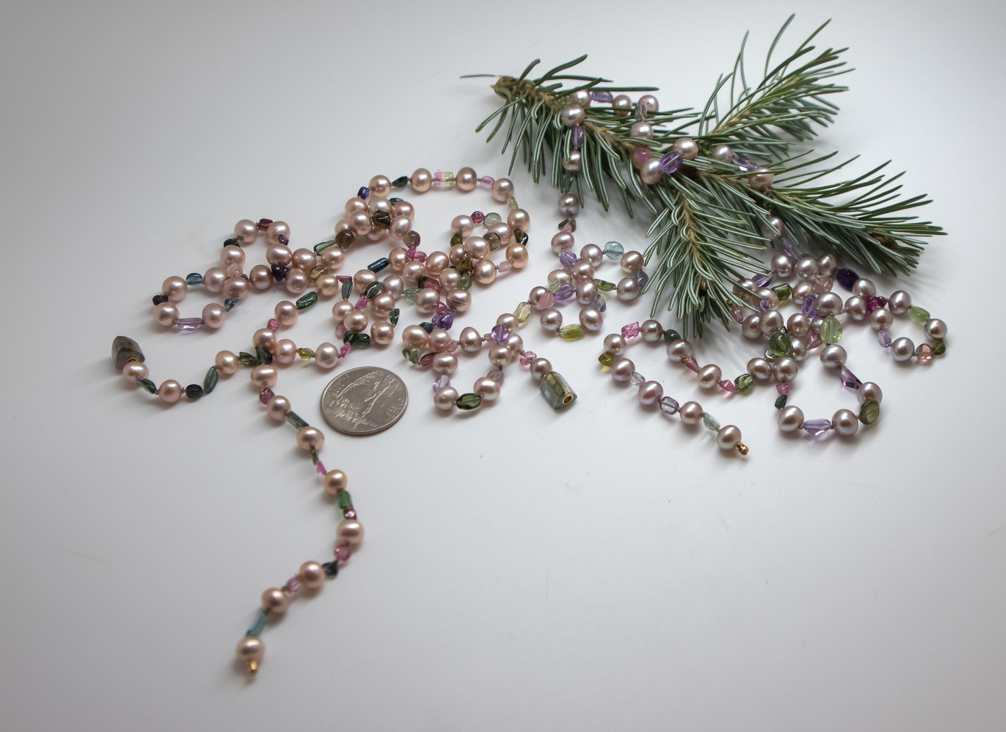 Tourmaline and Freshwater pearl necklace photographed with a Spruce sprig and US Quarter coin for scale