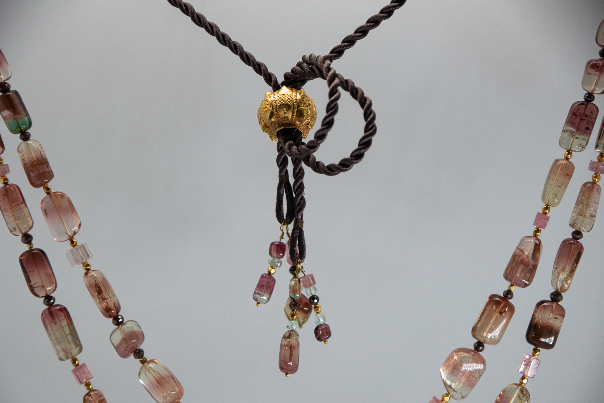closeup of antique gold bead slider on a tourmaline necklace